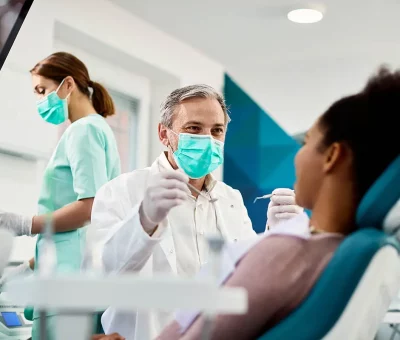 Group-Dental-Insurance-Woman-Getting-Her-Teeth-Cleaned-by-a-Dentist-and-an-Assistant